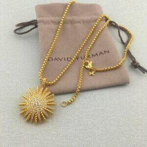 An 18K gold & diamond starburst pendant on 18 inch yellow gold chain